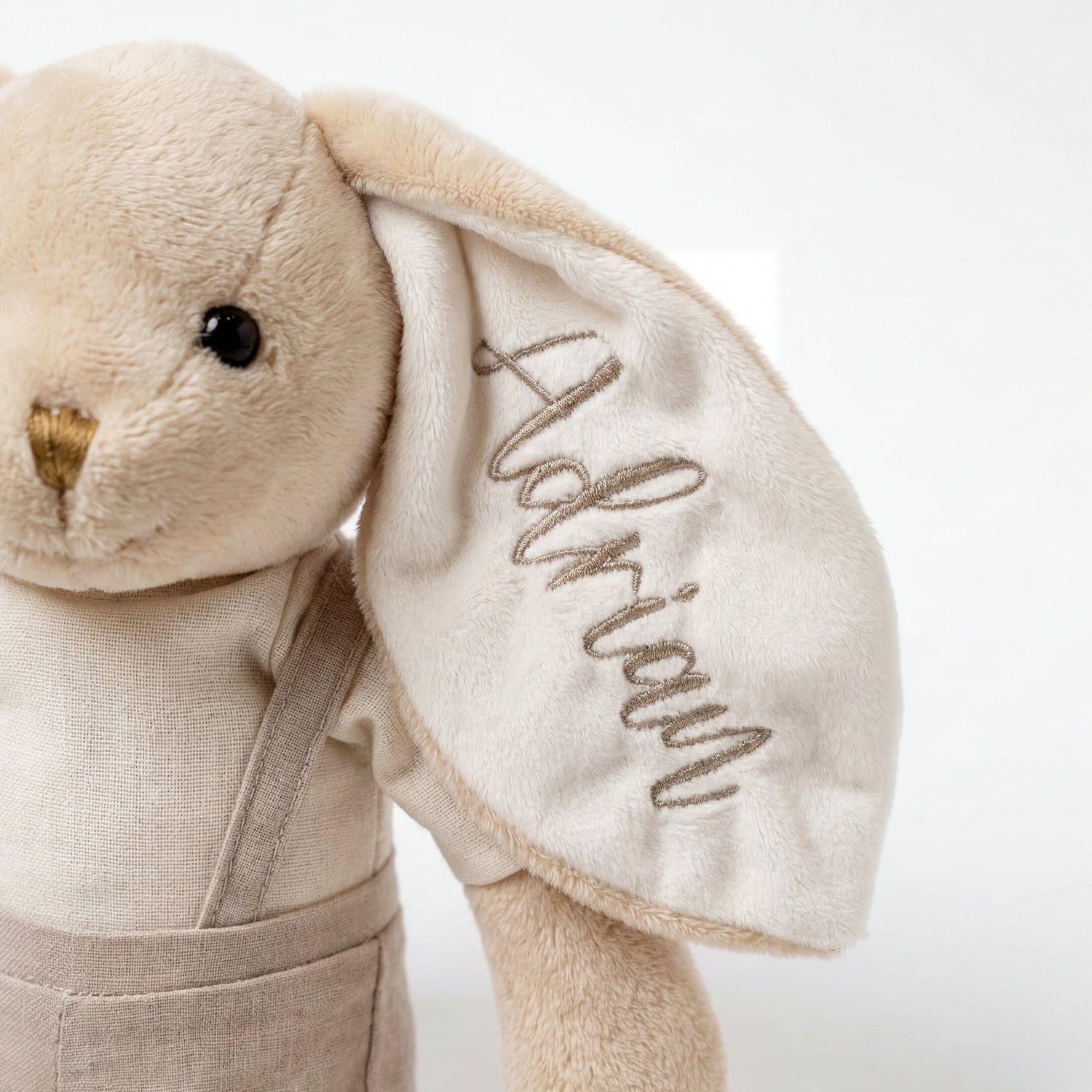 Beige stuffed animal with embroidered name on a white background